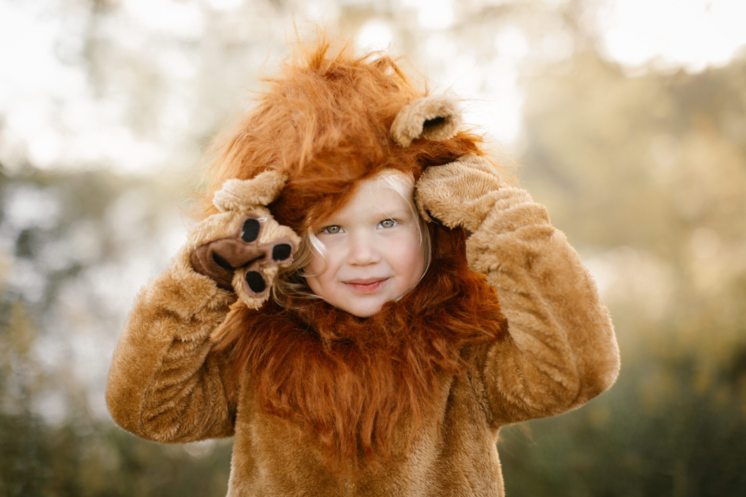 Super cute kid in a lion costume for Halloween family mini session shoot Excelsior Minnesota