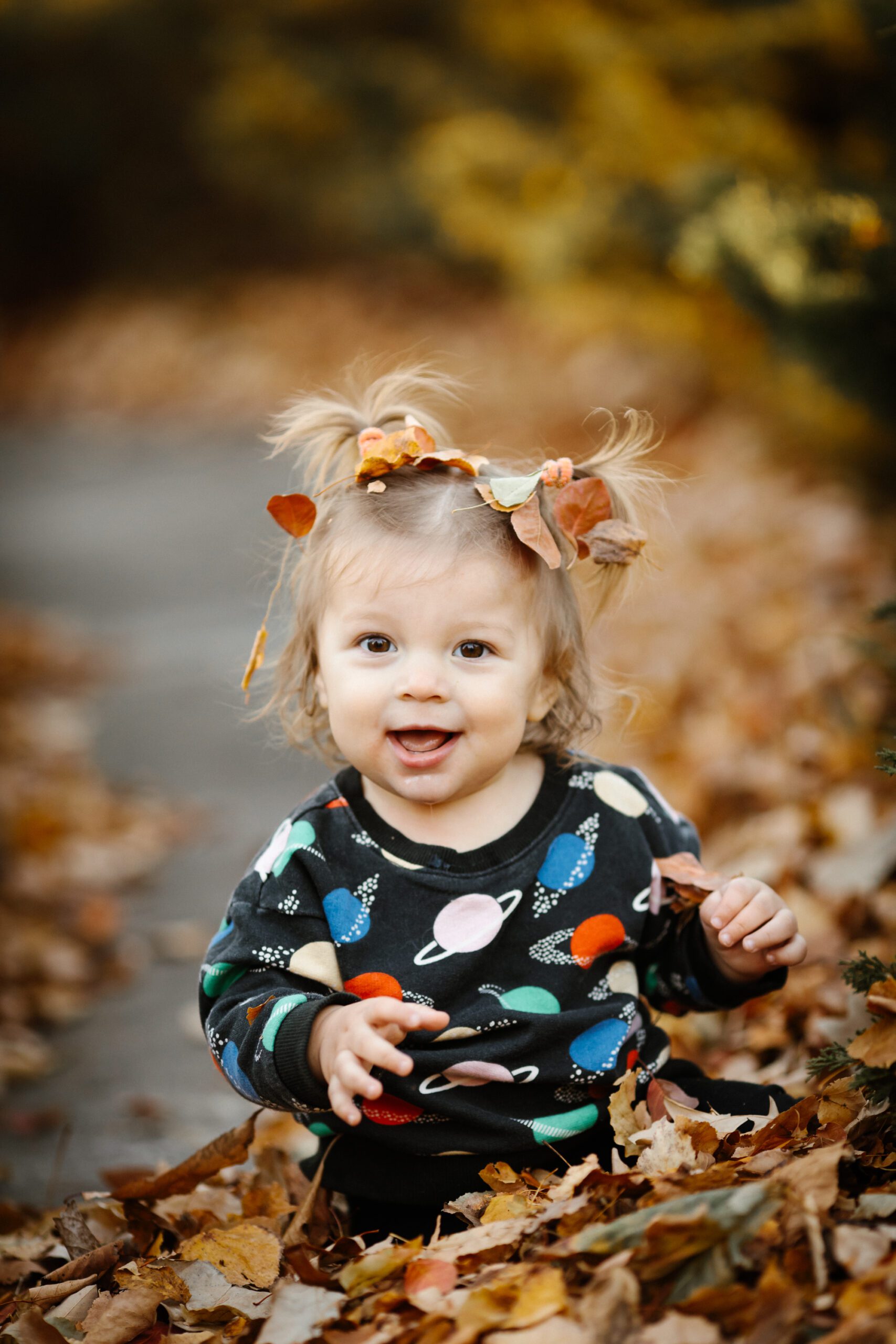 Baby playing in fall leaves portrait